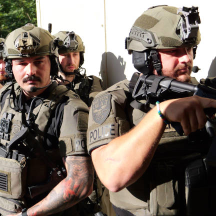 Dayton Police SWAT Officers approaching a corner in a breach position with rifle drawn.